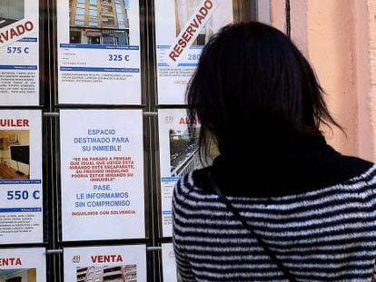 Una mujer mira los anuncios de una inmobiliaria en Valencia, en una imagen de archivo.