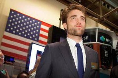 El actor Robert Pattinson participó este martes en la tradicional ceremonia de apertura de la bolsa de Nueva York, donde se agolparon decenas de curiosos para poder ver al codiciado actor británico promocionando su última película, "Cosmopolis", en la que encarna precisamente a un "tiburón" de Wall Street.