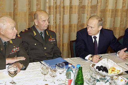 El presidente ruso, Vladímir Putin (derecha), conversa con mandos militares rusos, ayer en Moscú.