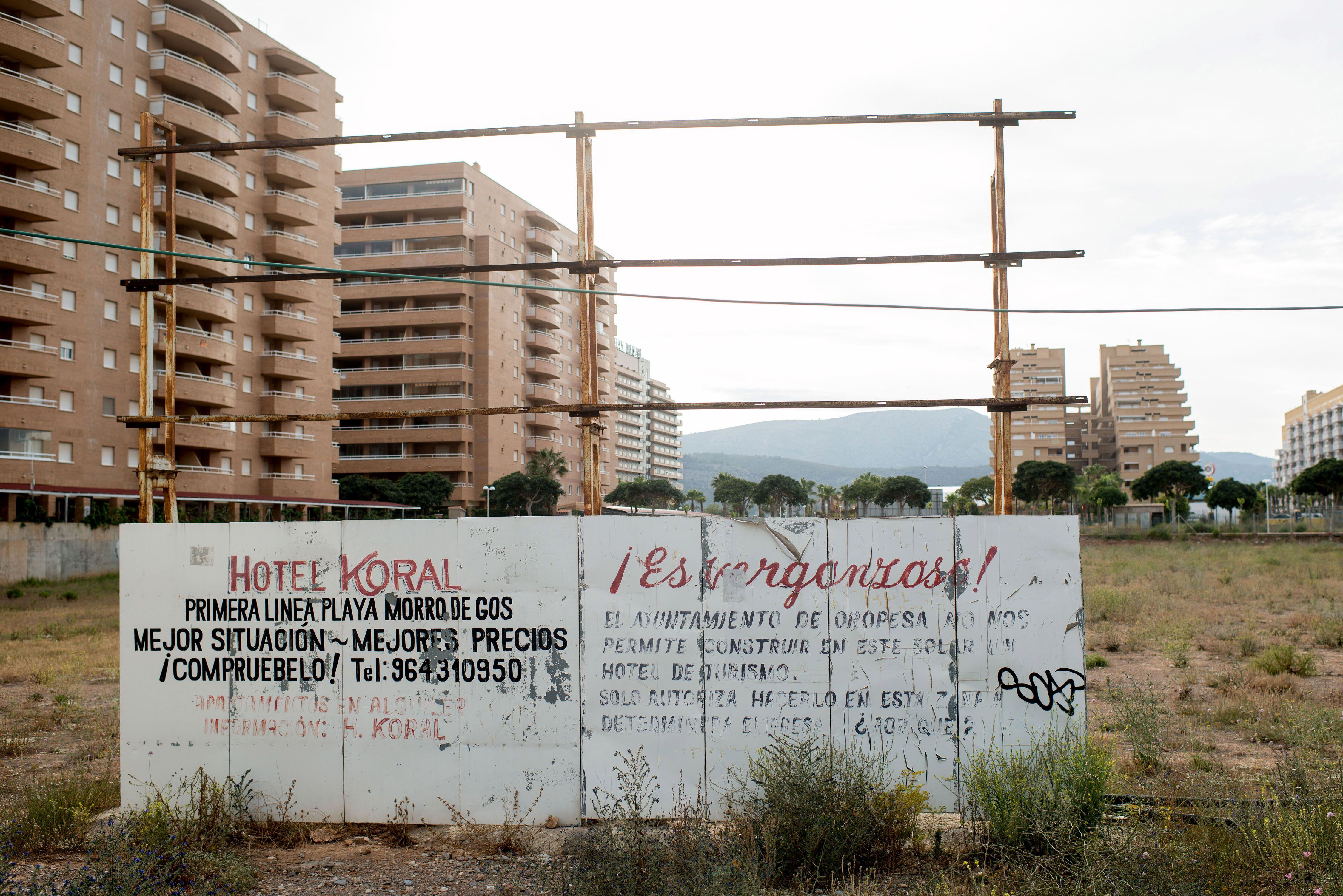 Un cartel roto y, al lado, uno de protesta, anuncian unas viviendas sin construir en Oropesa del Mar en 2014. 