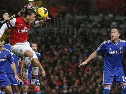 Cech despeja ante Özil y la mirada de Terry.