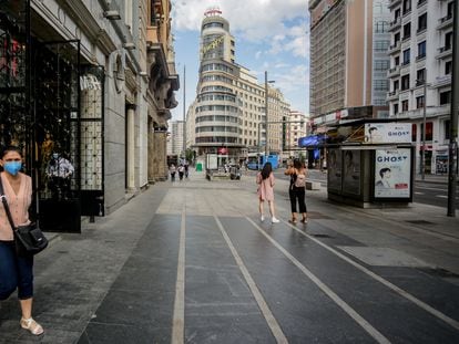 Varias personas salen de una tienda de moda en la Gran Vía, Madrid.