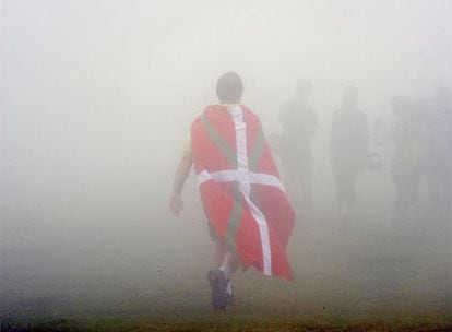 Un simpatizante del PNV, envuelto en la <i>ikurriña,</i> en el acto de homenaje a la enseña vasca celebrado ayer en el monte Gorbea.