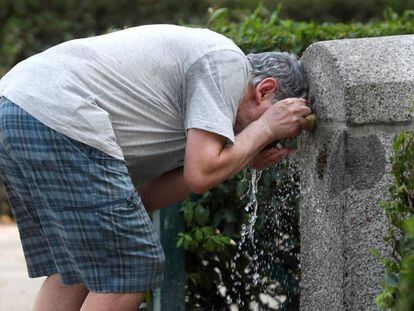 Un hombre se refresca en una fuente de un parque de Madrid el 3 de julio.