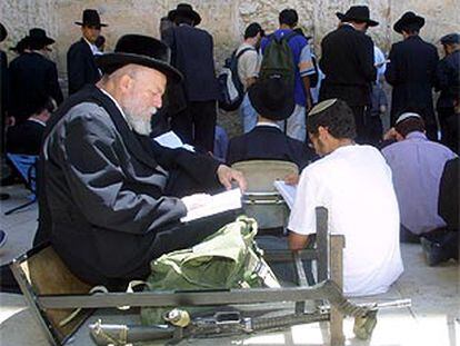 Un hombre lee un libro sagrado ante el Muro de las Lamentaciones, ayer durante la conmemoración de la destrucción del primer y segundo templo de Jerusalén.