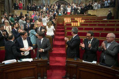 Los diputados independentistas aplauden la aprobaci&oacute;n de la ley del refer&eacute;ndum, con los esca&ntilde;os de la oposici&oacute;n vac&iacute;os, el 6 de septiembre.