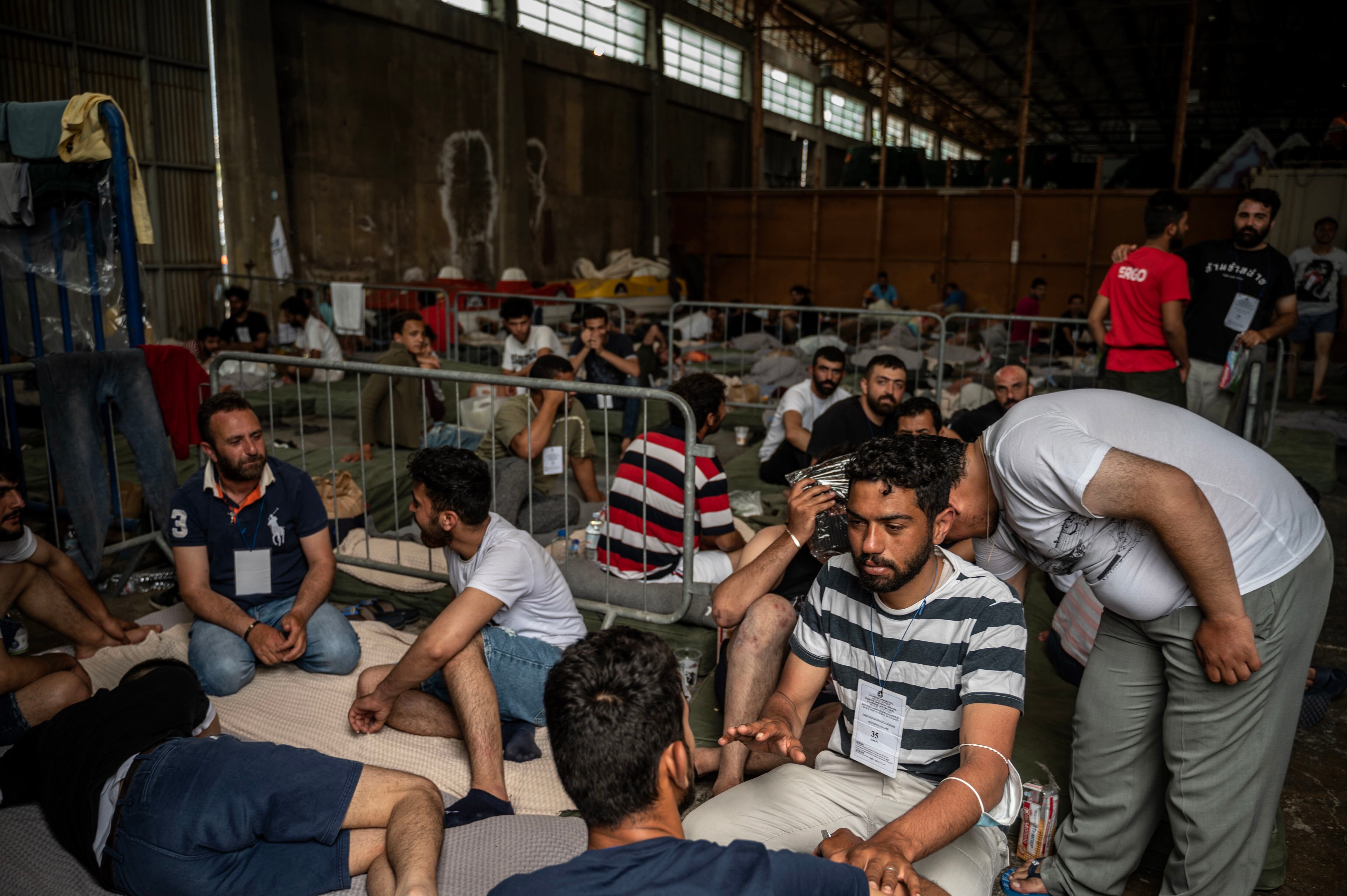 Migrantes supervivientes del naufragio descansan en un almacén en la ciudad portuario de Kalamata, este jueves.