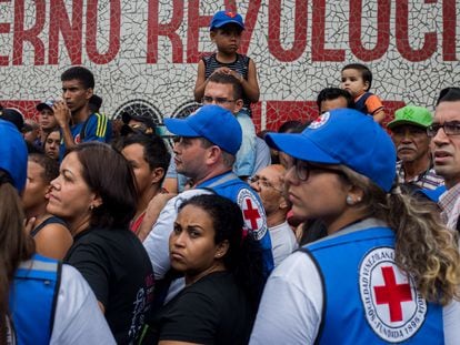 Personas esperan para recibir ayuda de trabajadores de la Cruz Roja en Venezuela.