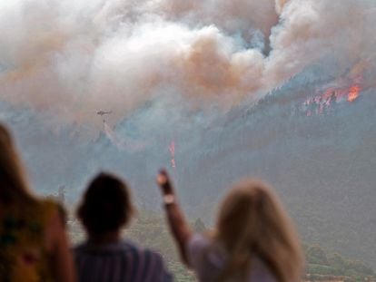 Vecinos del barrio de Las Llanadas, en el municipio tinerfeño de Los Realejos, observan el incendio que afecta al norte de la isla.