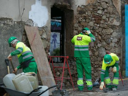 Tres operarios tapian las entradas del edificio que albergaba el Ateneu Popular de Sarrià.