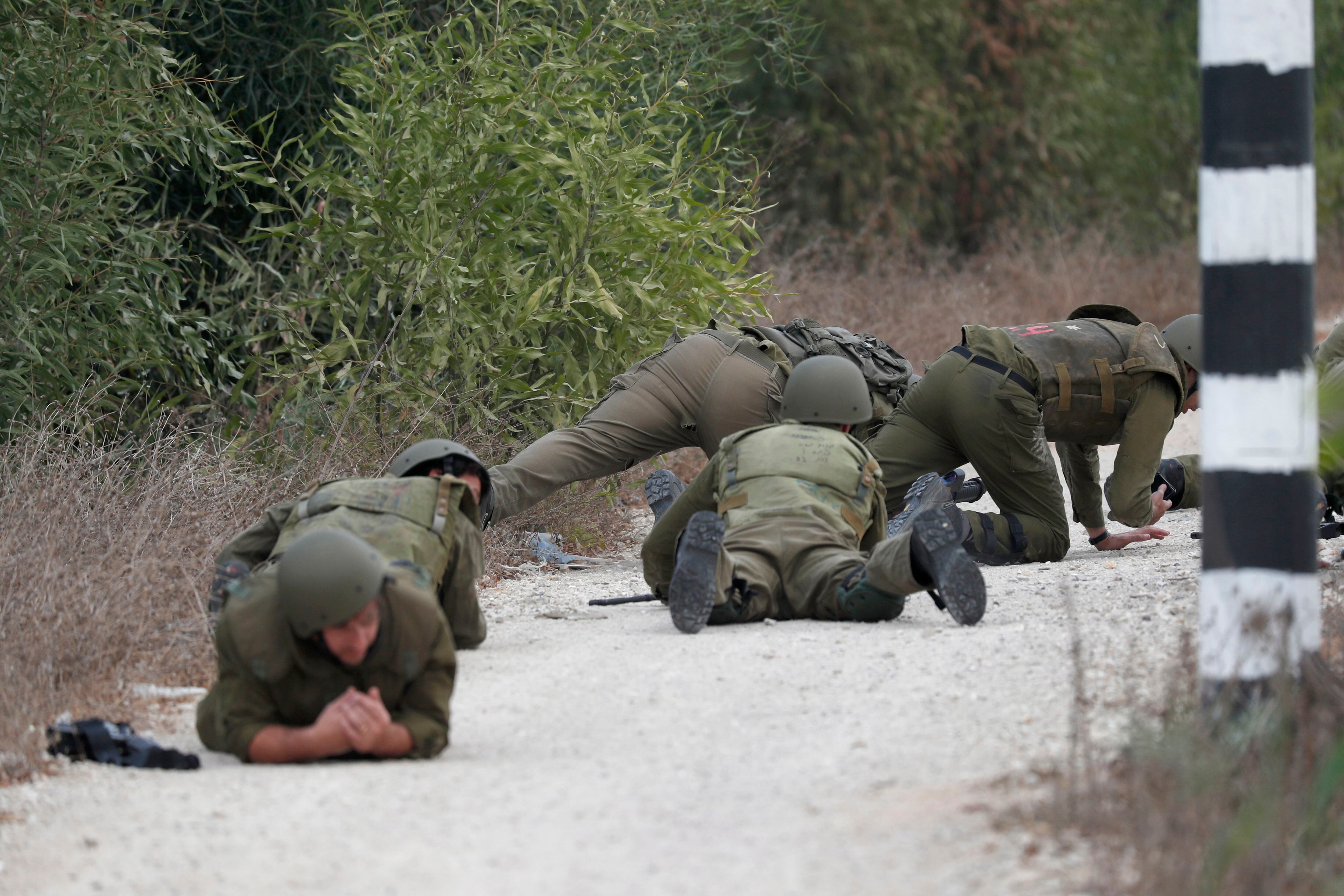 Soldados israelíes take cover during a missile attack next to the border with Gaza, near Sderot, southern Israel, 09 October 2023. The Israeli army announced on 09 October, it carried out over 500 strikes on targets across the Gaza Strip overnight. Palestinian officials said almost 500 people were killed and over 2,700 were injured after Israel launched retaliatory raids and air strikes. An unprecedented attack on southern Israel on 07 October claimed by the Islamist movement Hamas killed more than 700 Israelis and left over 2,150 injured, the Israeli army said. EFE/EPA/ATEF SAFADI