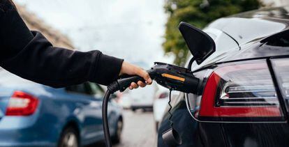 Una persona carga un coche eléctrico.