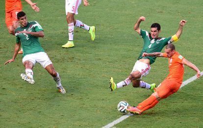 El centrocampista holandés Wesley Sneijder, dispara entre los defensores de México Francisco Rodríguez (i) y Rafael Márquez.
