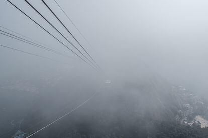 One of the cable cars crosses the clouds passing through the Pão de Açúcar.