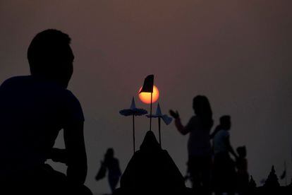 Un grupo de rakhinos permanecen junto a una estupa (monumento conmemorativo budista) hecho de arena, durante el Festival Sand Pagoda, celebrado en una playa de Sittwe, en el estado de Rakhine (Birmania).