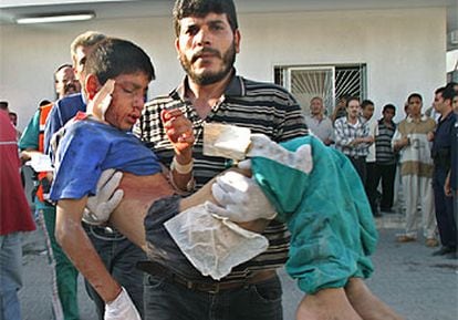 Un sanitario palestinos lleva en brazos a un niño herido en el campo de refugiados de Yebalia.