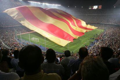 Una senyera gigante cubre el césped de Camp Nou durante un partido de Liga de Campeones ante el Milán