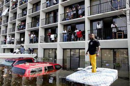 Policías y voluntarios de Nueva Orleans rescatan, con ayuda de una lancha, a vecinos atrapados en un edificio inundado.