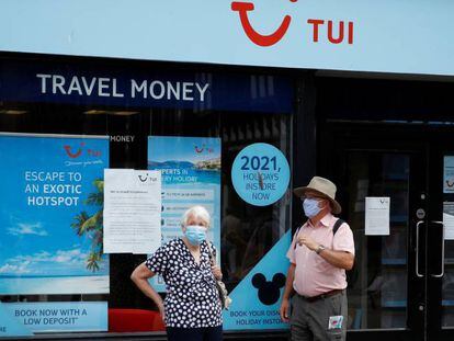 Dos personas con mascarilla frente a una tienda del turoperador Tui en Chester, Reino Unido. 