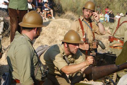 En los momentos previos del enfrentamiento decisivo entre nacionales y republicanos, participantes vestidos de soldados se preparan en las trincheras para simular la defensa.