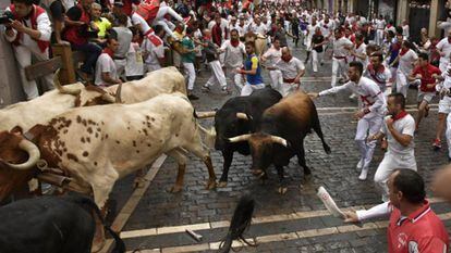Corredores participando en un encierro de sanfermines.