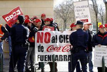 Trabajadores de Coca Cola portan pancartas durante una concentración llevada a cabo en las inmediaciones de la Asamblea de Madrid para exigir a la empresa que dé marcha atrás en sus planes para cerrar su planta de Fuenlabrada. EFE/Archivo