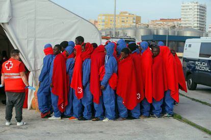 Varios inmigrantes forman fila tras desembarcar en Málaga este martes.