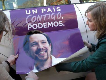 Tania Sánchez (Podemos) coloca publicidad electoral de su partido en un taxi.