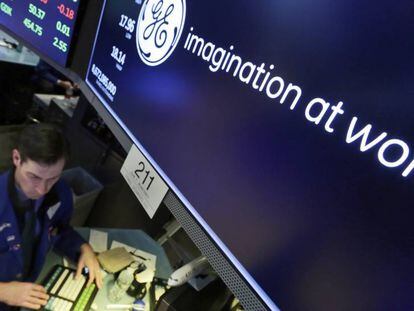 Un agente burs&aacute;til en Wall Street bajo el monitor con la cotizai&oacute;n de General Electric