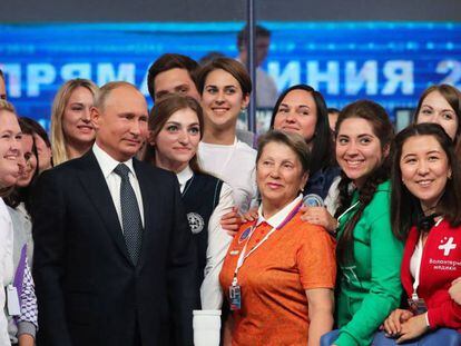 El presidente ruso, Vladímir Putin, posa con un grupo de voluntarios tras su programa nacional en directo.