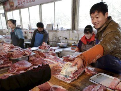 Una mujer compra en una carnicer&iacute;a de Pekin. 