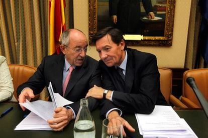 El gobernador del Banco de España, Miguel Angel Fernández Ordóñez charla con el diputado Antonio Gutiérrez, durante la Comisión de Economía y Hacienda del Congreso.