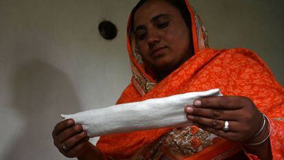Hajra Bibi sostiene una de las compresas que fabrica en su casa.