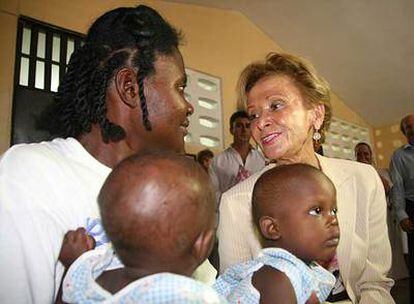 Fernández De la Vega, con los bebés Oader y Oudur, y la madre de éstos, en el barrio haitiano de Cité Soleil.
