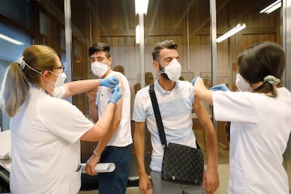 Dos hombres son vacunados contra el coronavirus en Valencia este verano.