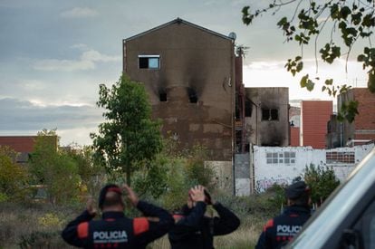 Mossos d'Esquadra custodian los alrededores de la nave mientras los bomberos realizan su trabajo.