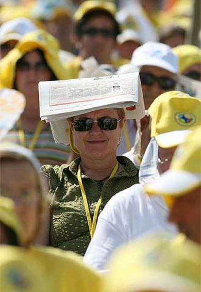 Una peregrina mitiga los efectos del sol con un periódico.