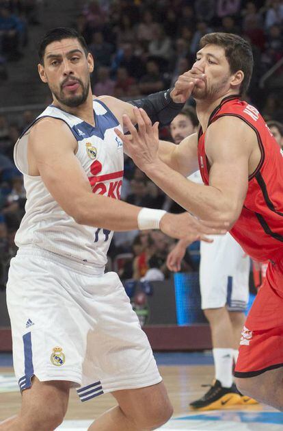 Los pivots del Real Madrid, el mexicano Gustavo Ayón (i) y del Valencia Basket, el ucraniano Viacheslav Kravtsov, pelean durante el encuentro.