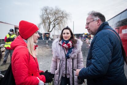Sofya, una joven ucrania que huyó de la guerra en la región de Donetsk, y Venetta, una joven estadounidense de origen ucranio y búlgaro que rápidamente cruzó la frontera para ayudar a refugiados llegados de Ucrania, charlan con otro desplazado.
