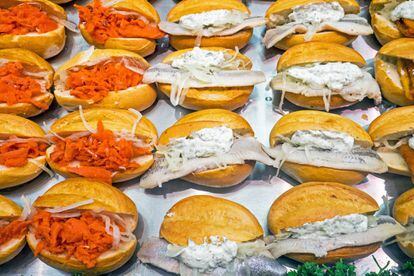 En alemán, 'fischbrötchen' significa panecillo de pescado, lo que da una idea bastante aproximada de lo que vamos a encontrar dentro del bollo de pan de harina de trigo o de centeno: cebolla cruda y pescado que suele ser arenque encurtido o marinado (aunque a veces se sirve frito). En algunos sitios le añaden salsa 'remoulade' (a base de mostaza y mayonesa), pepinillos o lechuga. Es un sándwich típico del <a href="https://elviajero.elpais.com/tag/alemania/a" rel="nofollow" target="_blank">norte de Alemania</a>, tanto que la primera edición de la Feria de Hannover —la feria industrial más grande del mundo— se conoció coloquialmente como Feria de Fischbrötchen, ya que estaba exenta del racionamiento de alimentos (estamos hablando de la Alemania de 1947, en plena posguerra) y los invitados eran recibidos con este aperitivo. En 2014, la revista 'Time' lo incluyó en un artículo sobre los 13 sándwiches más asombrosos del mundo.