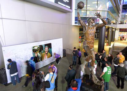 El mural dedicado a Jerry Buss, junto a la estatua en honor a Kareem Abdul-Jabbar situada en el exterior del Staples Center.