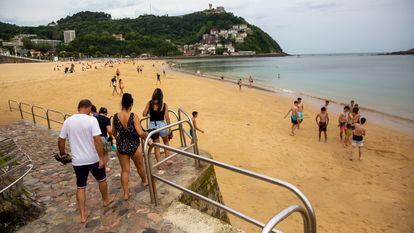 Bañistas se dirigen a la playa de Ondarreta de San Sebastián (Gipuzkoa) durante este miércoles de calor.