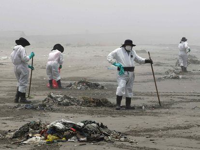 Personal limpia y recoge basura en la playa Cavero en el distrito de Ventanilla en Lima (Perú).