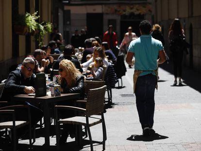 Un camarero sirve en una terraza en Madrid