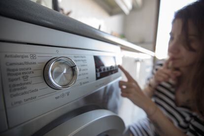 Una mujer pone la lavadora en su casa de Madrid.