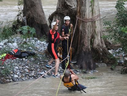 Elementos de un equipo de Protección Civil de Nuevo León participan en el rescate de personas que quedaron atrapadas en la corriente del río La Silla, en Nuevo León.