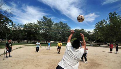 Un grupo de ecuatorianos jugando al ecuavóley (una variante del voleibol) en el parque.
