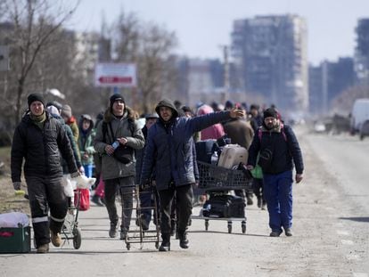 Unos civiles abandonaban la ciudad ucrania de Mariupol por un corredor humanitario, en marzo de 2022, durante el asedio de las tropas rusas.