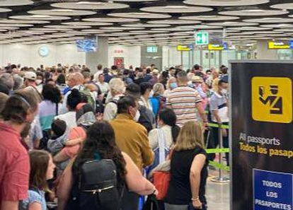 Decenas de viajeros esperando esta mañana en el control de pasaportes de Madrid-Barajas.