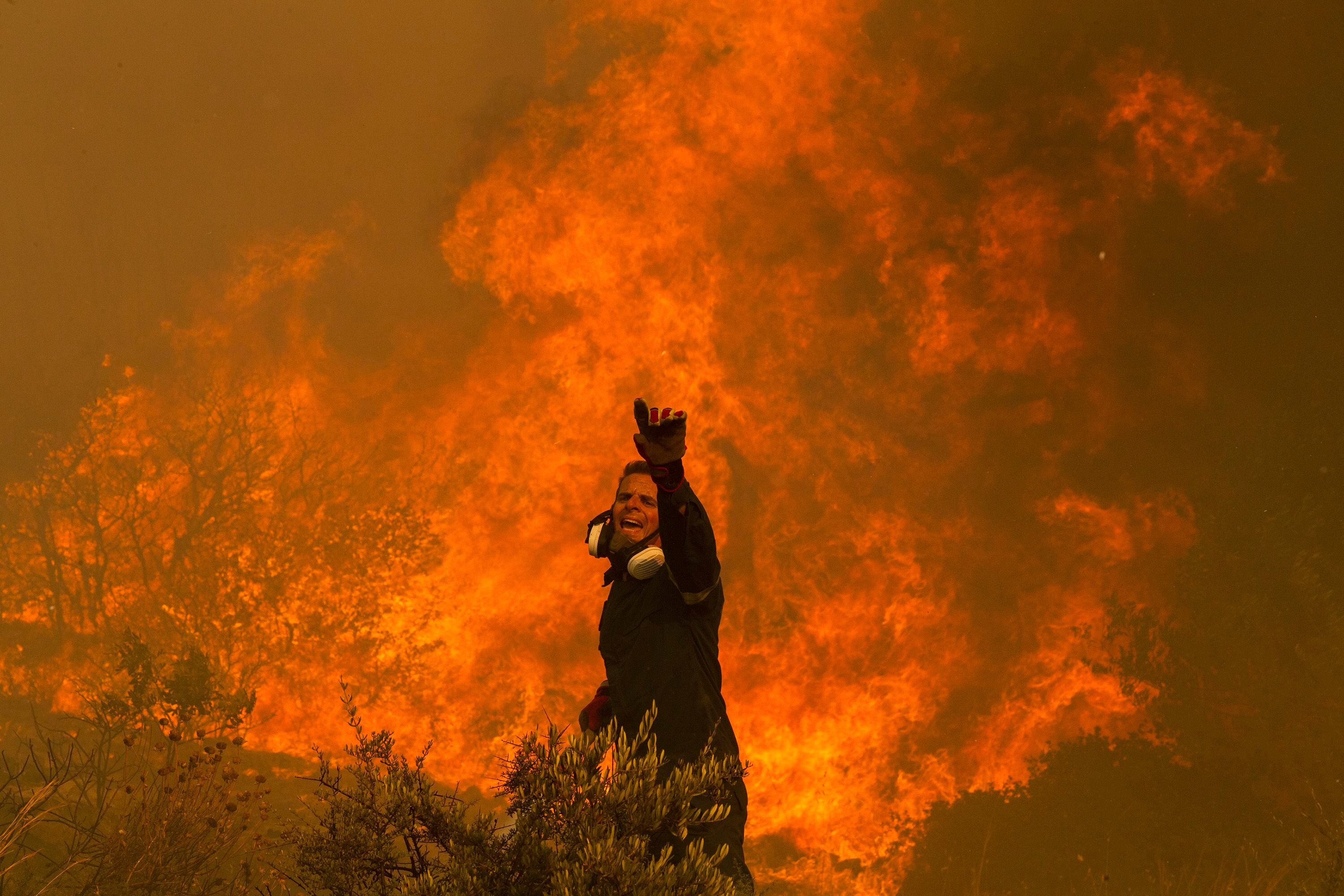 Un bombero trabaja por apagar las llamas en el pueblo de Hasia, cerca de Atenas (Grecia), el martes 22 de agosto. 